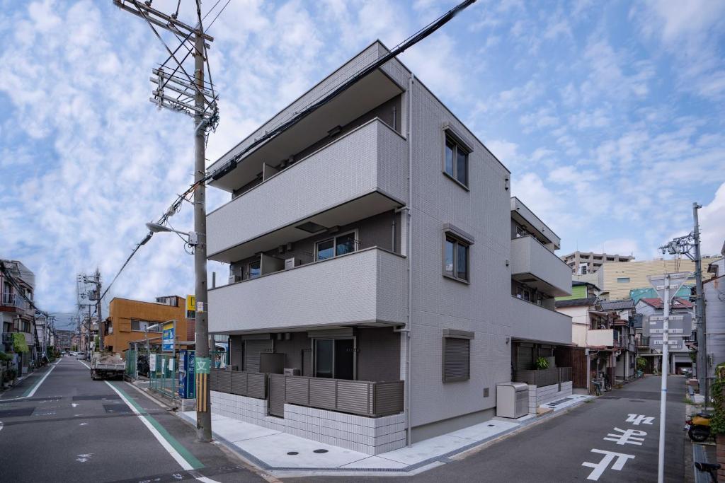 a white building on the side of a street at 震雲マンション103 in Osaka