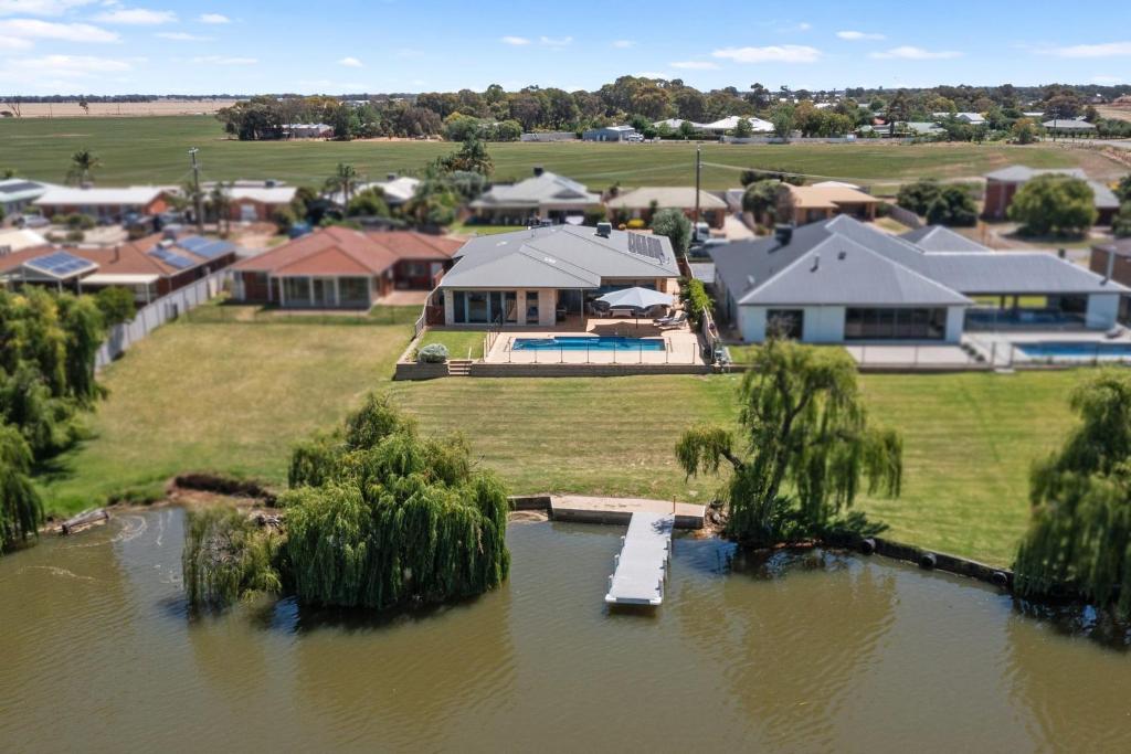 una vista aérea de una casa con un muelle en el agua en The Lakehouse on Rosemary, en Yarrawonga