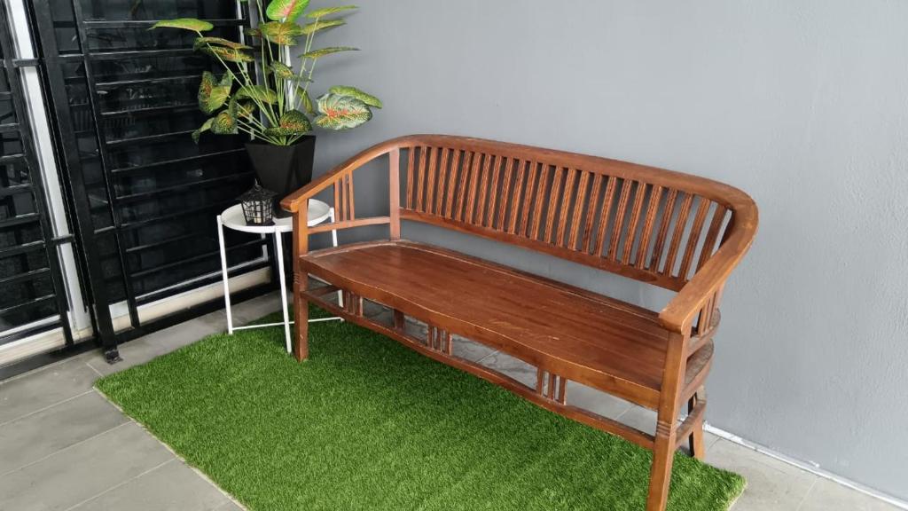 a wooden bench sitting on top of a green rug at Homestay Afeef Jerantut in Jerantut
