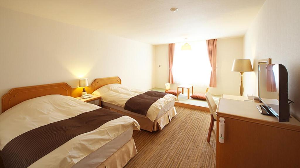 Postel nebo postele na pokoji v ubytování Motosu Phoenix Hotel