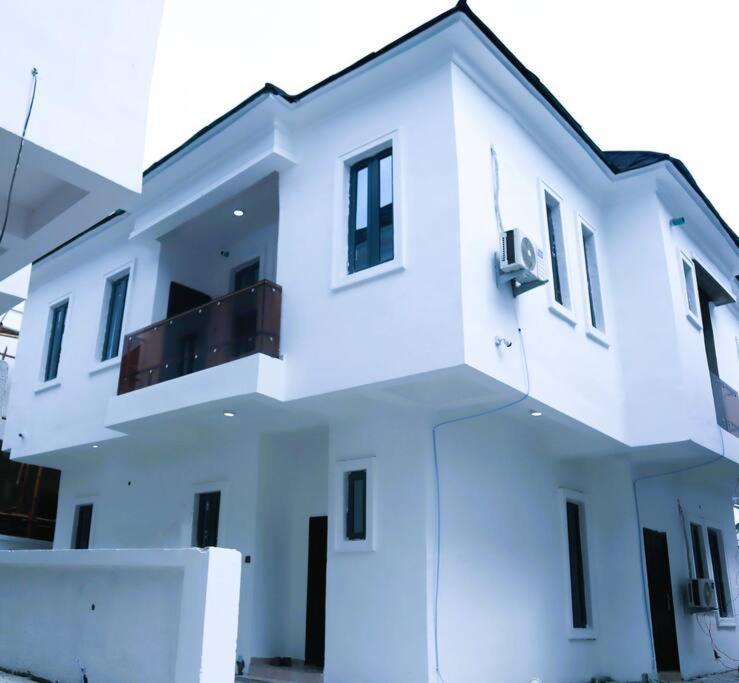 a white building with a balcony on top of it at Luxury Charming 5Bed Duplex With Starlink wifi - Lekki in Ikota