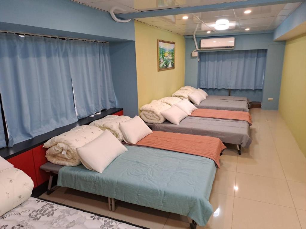 a row of beds in a room with blue walls at EZ Stay Hotel in Taipei