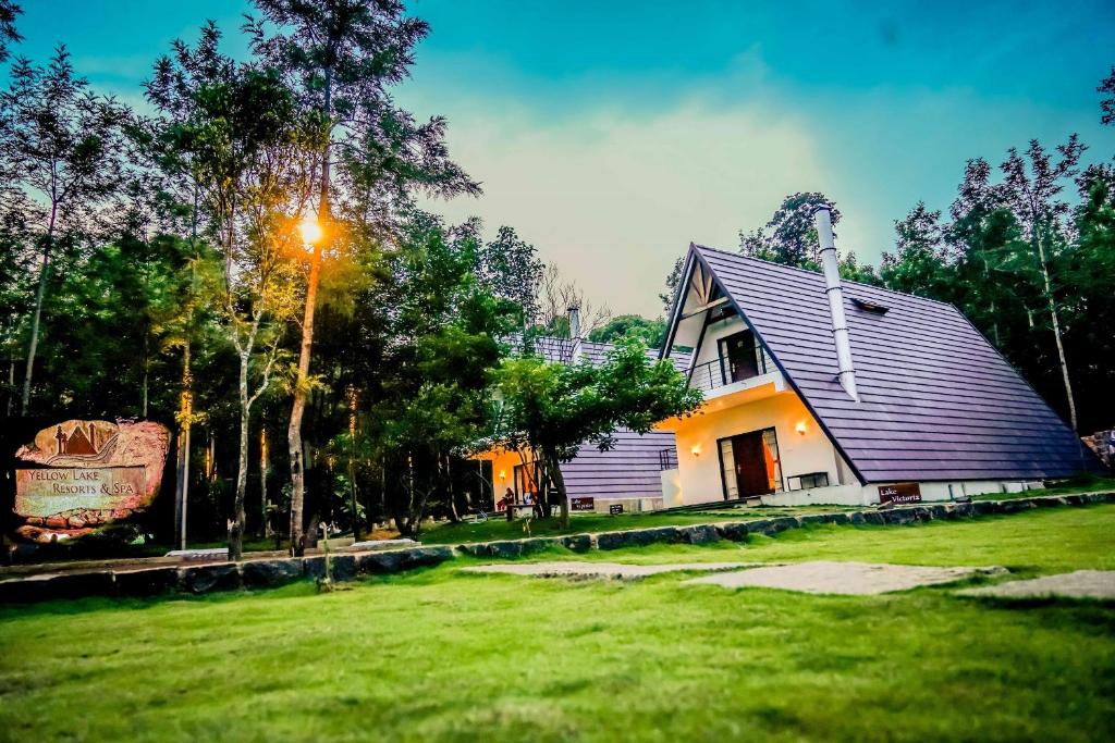 a house with a light on the side of a yard at YELLOW LAKE RESORTS & SPA, Yercaud in Yercaud
