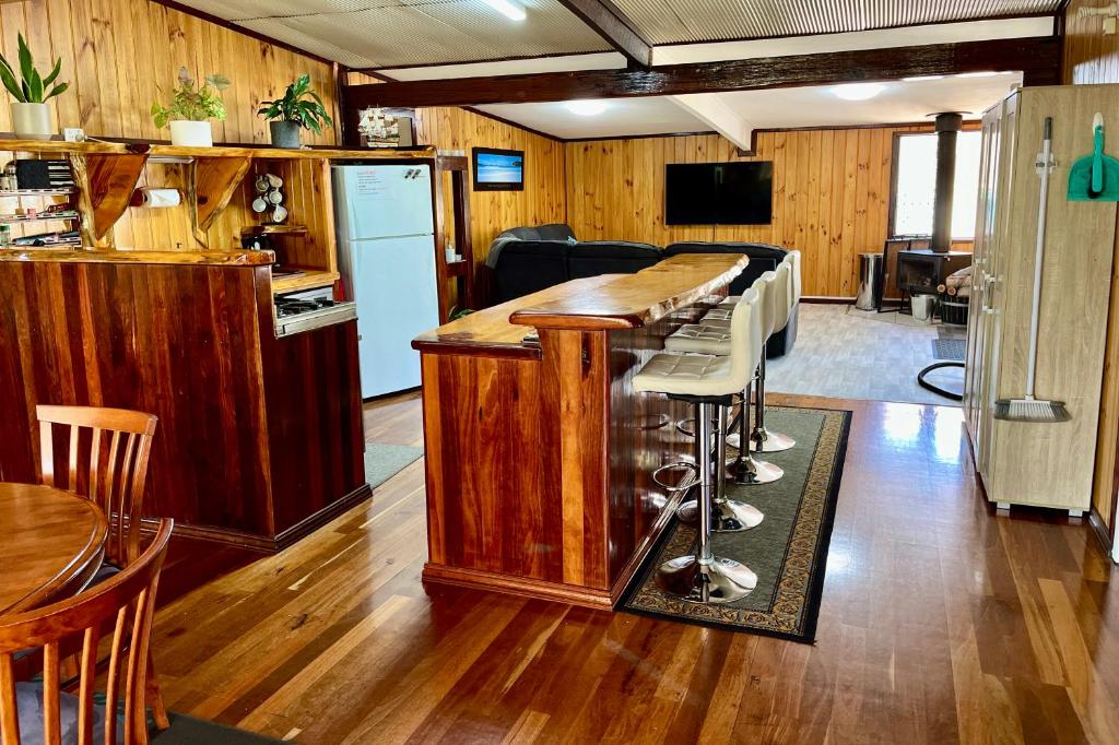 a kitchen with a counter with a bar with stools at Rustic Retreat Esperance in Esperance