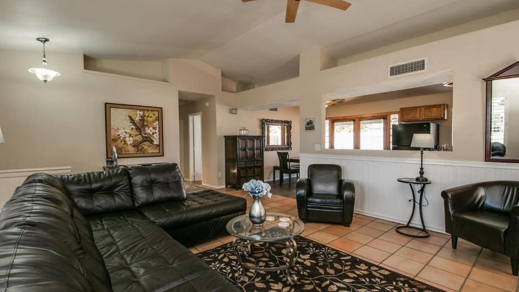 ein Wohnzimmer mit einem Ledersofa und einem Tisch in der Unterkunft Scottsdale Kierland 3 Bdrm with Sparkling Pool in Scottsdale