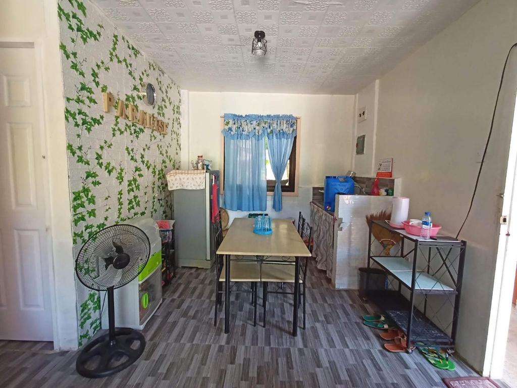 Kleines Zimmer mit einem Tisch und einem Kühlschrank. in der Unterkunft Jodels Paradise in Ligao