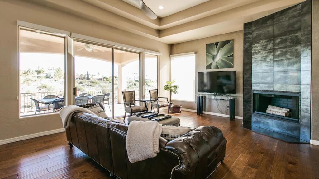 a living room with a leather couch and a fireplace at Fabulous 4-Bdrm WBreathtaking Views & Pool in Fountain Hills