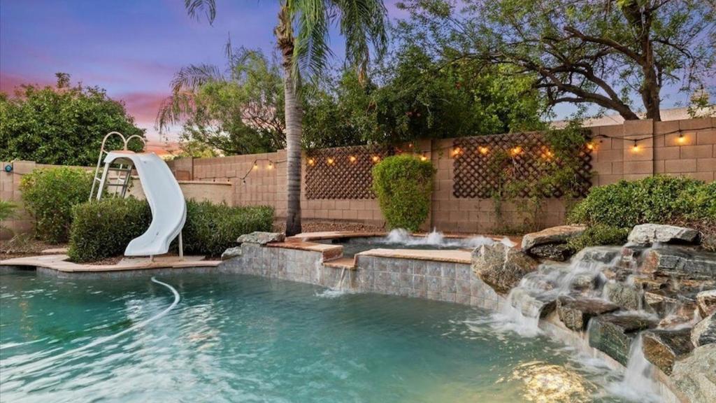 a swimming pool with a water slide in a yard at Massive North Scottsdale 6 bdrm w Oasis Backyard in Phoenix