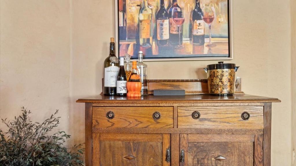 un comò in legno con bottiglie di vino sopra di New listing Charming 4 bedroom with Pool a Peoria