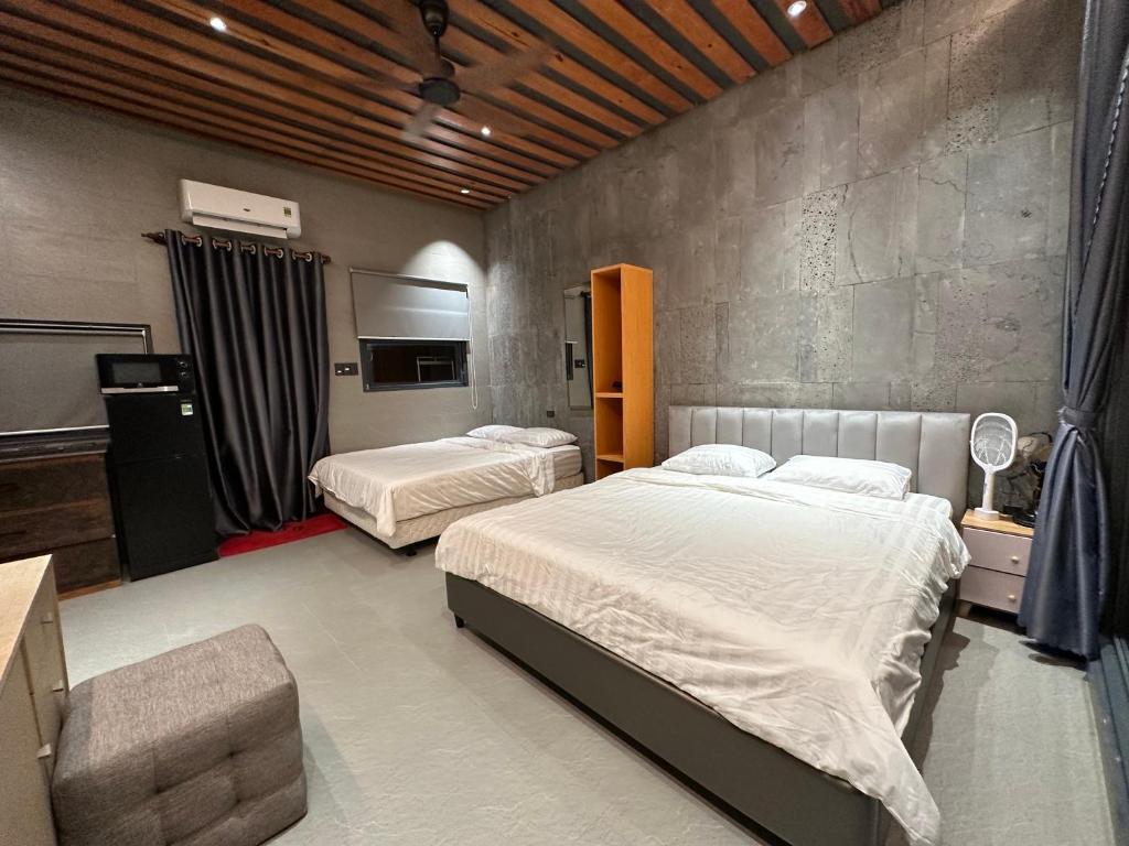 a bedroom with two beds and a chair at MAYHOME Ninh Chu - Phòng đôi lớn in Bắc Sớn
