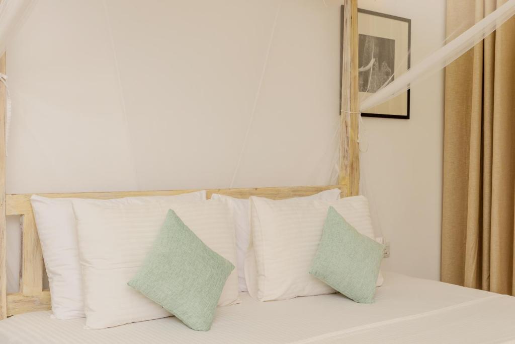 a group of pillows sitting on top of a bed at Aurora in Unawatuna