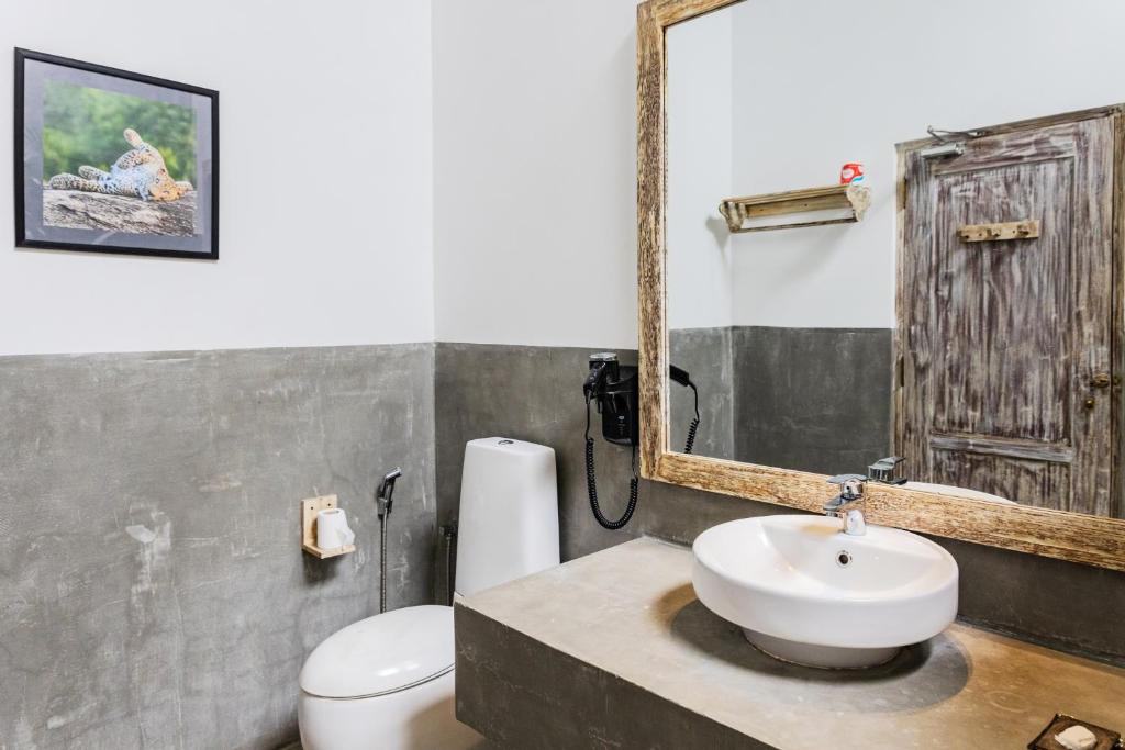 a bathroom with a sink and a toilet and a mirror at Aurora in Unawatuna