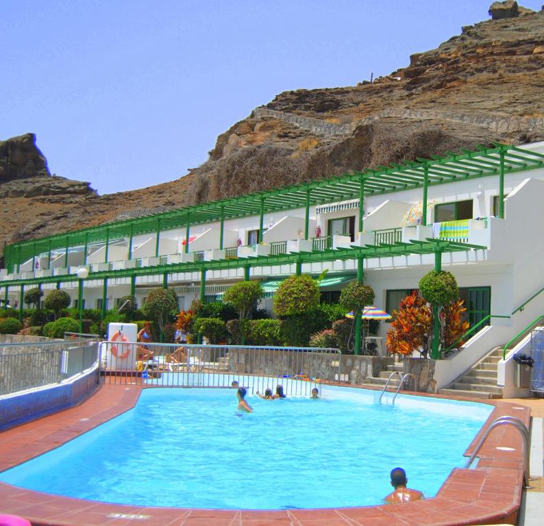una piscina en un hotel con gente dentro en Apartamentos Los Veleros, en Puerto Rico de Gran Canaria
