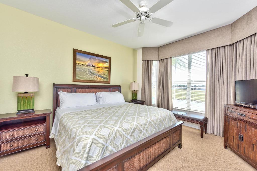 a bedroom with a bed and a flat screen tv at Genoa Vacation Rental in Naples
