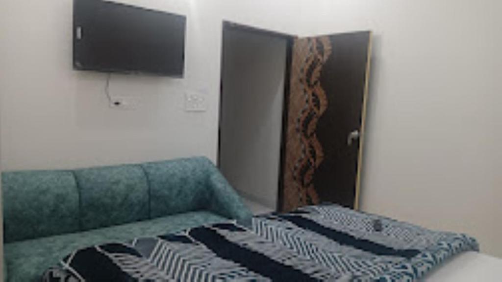 Kurukshetra的住宿－Hotel D9 Kurukshetra , Kurukshetra，一间设有绿色沙发和墙上电视的房间