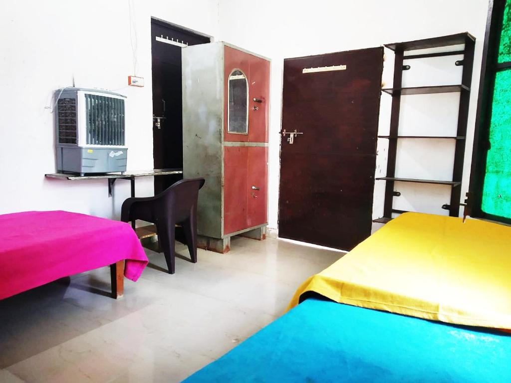 um quarto com 2 camas e uma secretária com um computador em Baba Boys Hostel and Baba Trailer Truck Transport em Lucknow