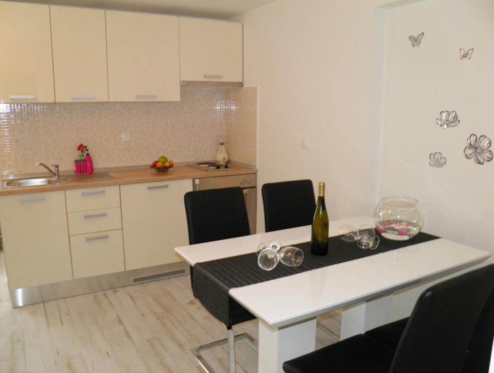 a kitchen with a table with a bottle of wine at Apartment Leptir in Podstrana