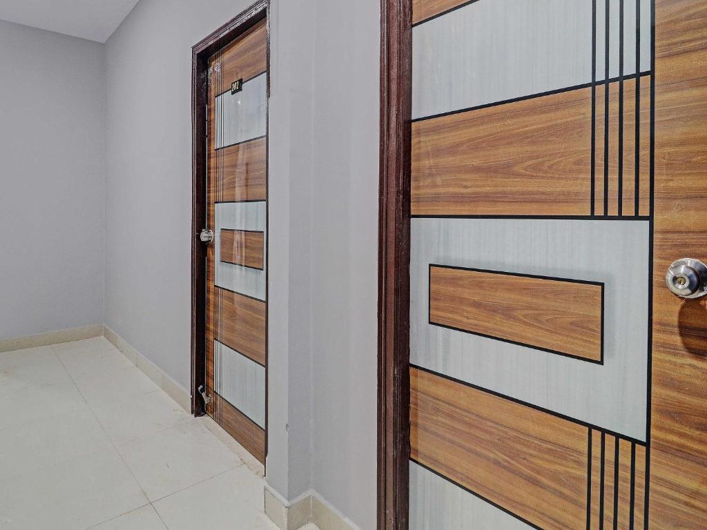 a door in a room with wooden panels at Collection O Hotel Lavish Springs in Hyderabad