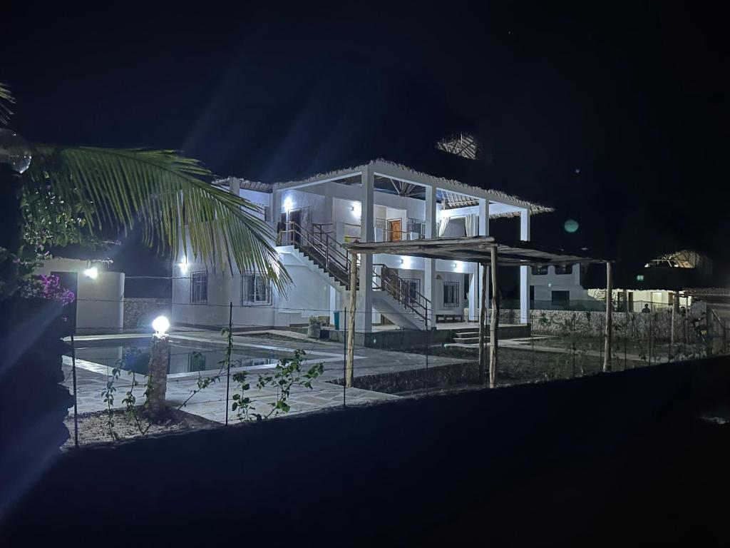 una casa di notte con una piscina di fronte di Nyumbani Tamu a Watamu