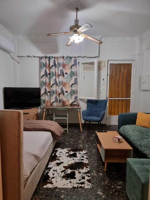 ein Wohnzimmer mit einem Sofa und einem Deckenventilator in der Unterkunft Peace'nQuiet - 200m Nikaia Metro - Detached House with Terrace in Piräus