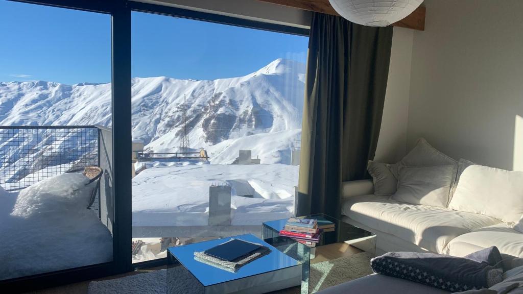 a living room with a view of a snowy mountain at Mariam's Stunning and Sunny Apt in Gudauri