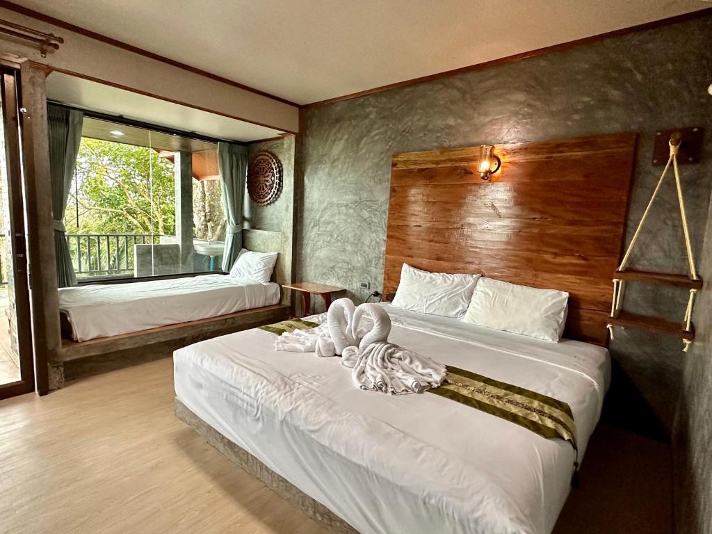 a bedroom with two beds with towels on them at Rinna Resort in Ko Mook