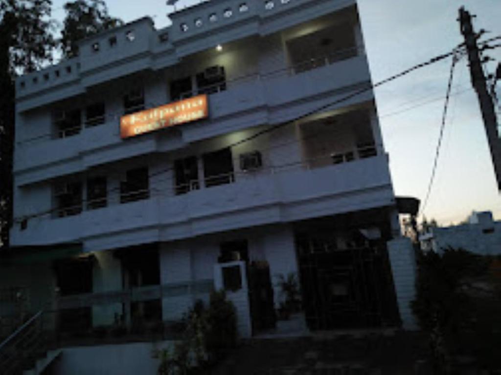 um edifício branco alto com um cartaz em Kalpana guest house , Bareilly em Bareilly