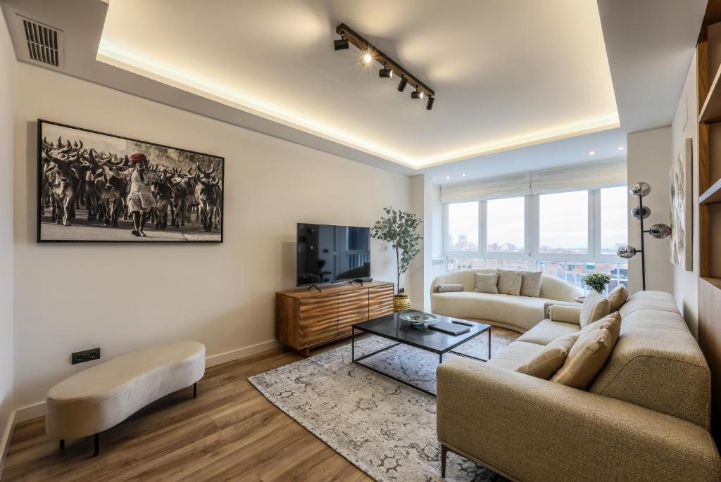 a living room with a couch and a tv at Luxury Plaza De Castilla in Madrid