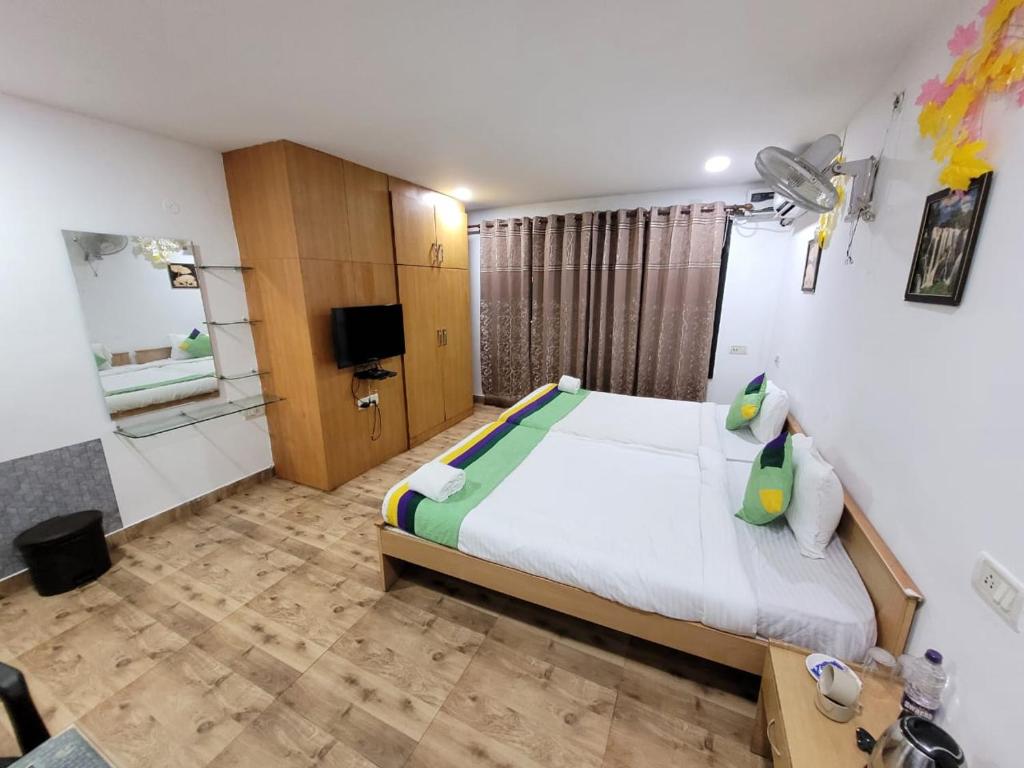 PuHoR Hotel Plaza Inn في غاواهاتي: غرفة نوم بسرير كبير وتلفزيون