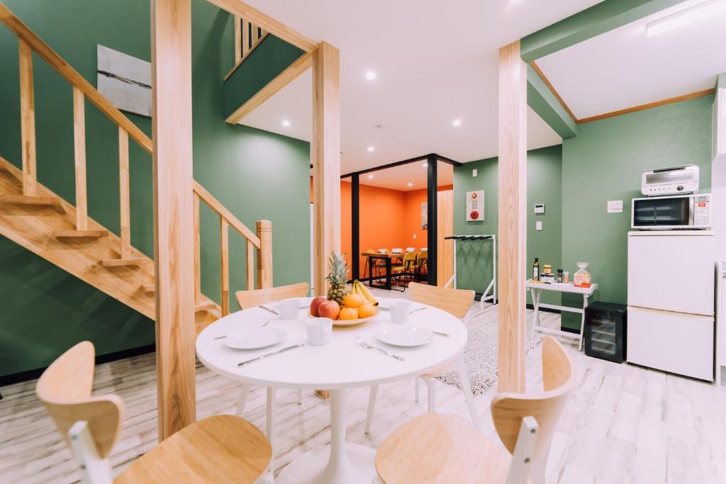 a kitchen and dining room with a white table and chairs at Yuzawa Onsen Lodge 1min to LIFT A House in Seki