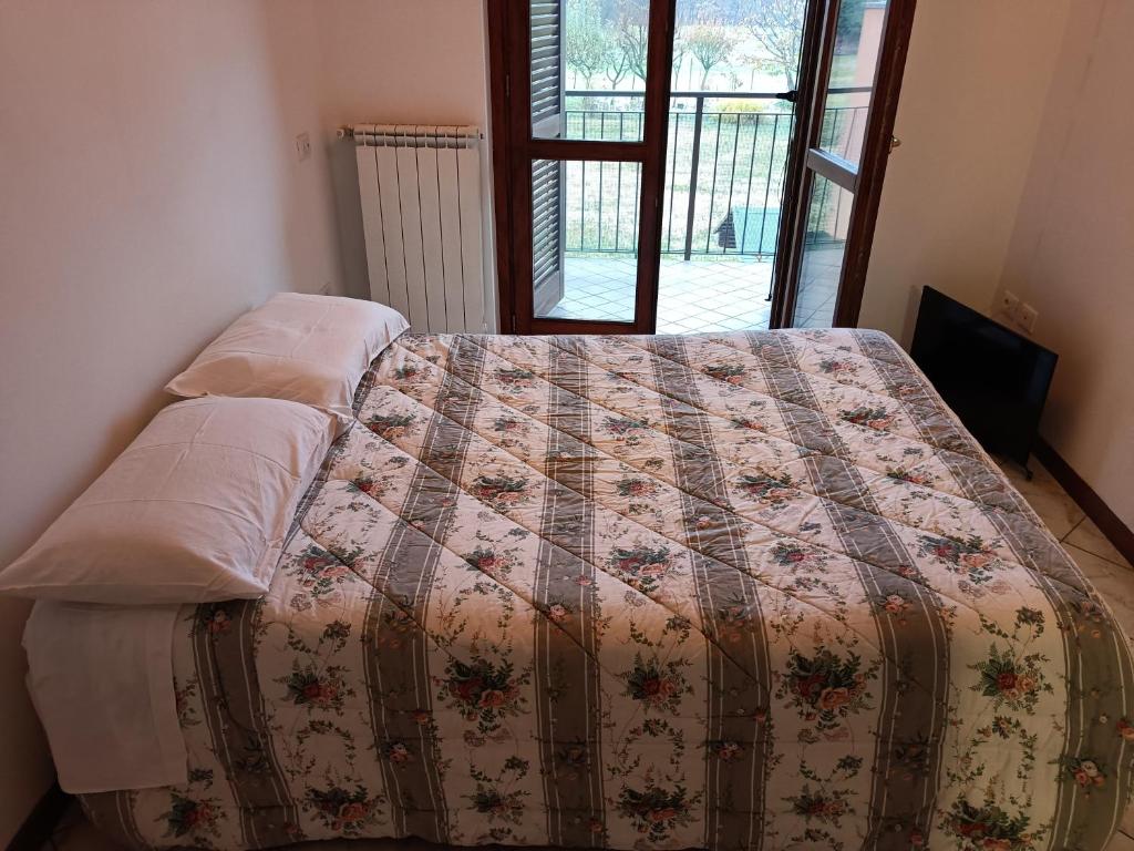 Una cama con edredón en un dormitorio en Matteotti 21, en Occhieppo Inferiore
