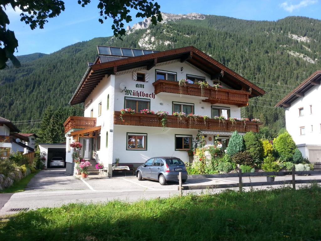 ein Gebäude mit einem davor geparkt in der Unterkunft am Mühlbach - Pension Luttinger in Bichlbach