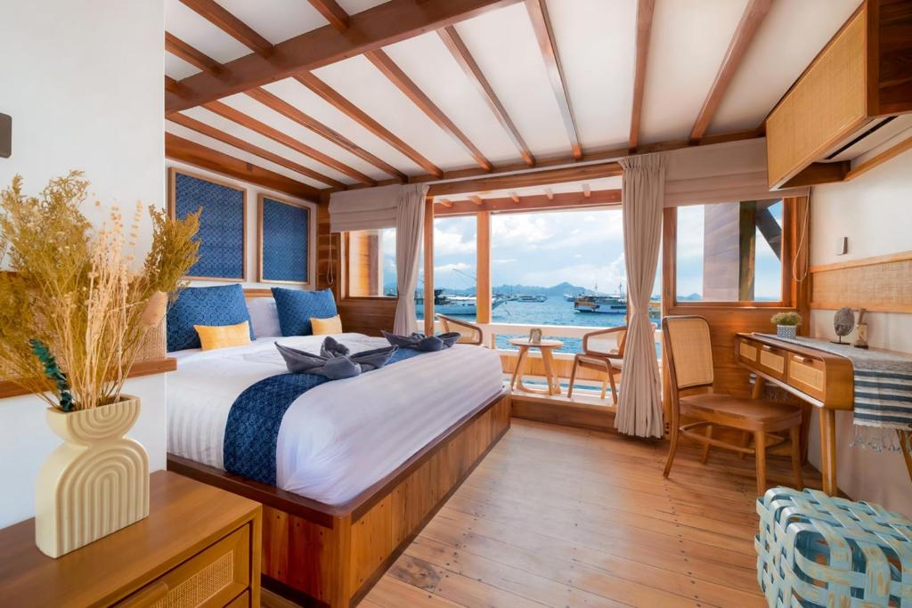 1 dormitorio en un yate con cama y escritorio en Labuan Bajo Trip, en Nggorang
