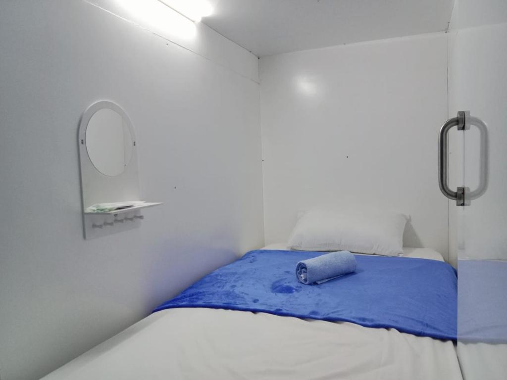 מיטה או מיטות בחדר ב-TAMU CAPSULE HOTEL
