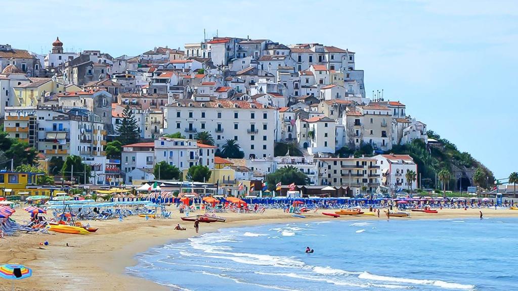 a group of people on a beach with buildings at Hotel Alba Living Room in Rodi Garganico