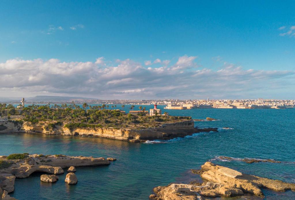 een uitzicht op de oceaan met rotsen in het water bij Minareto in Siracusa