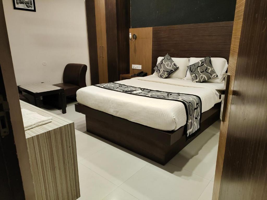 a hotel room with a bed and a chair at Santhi Bhavan, Chennai Central in Chennai