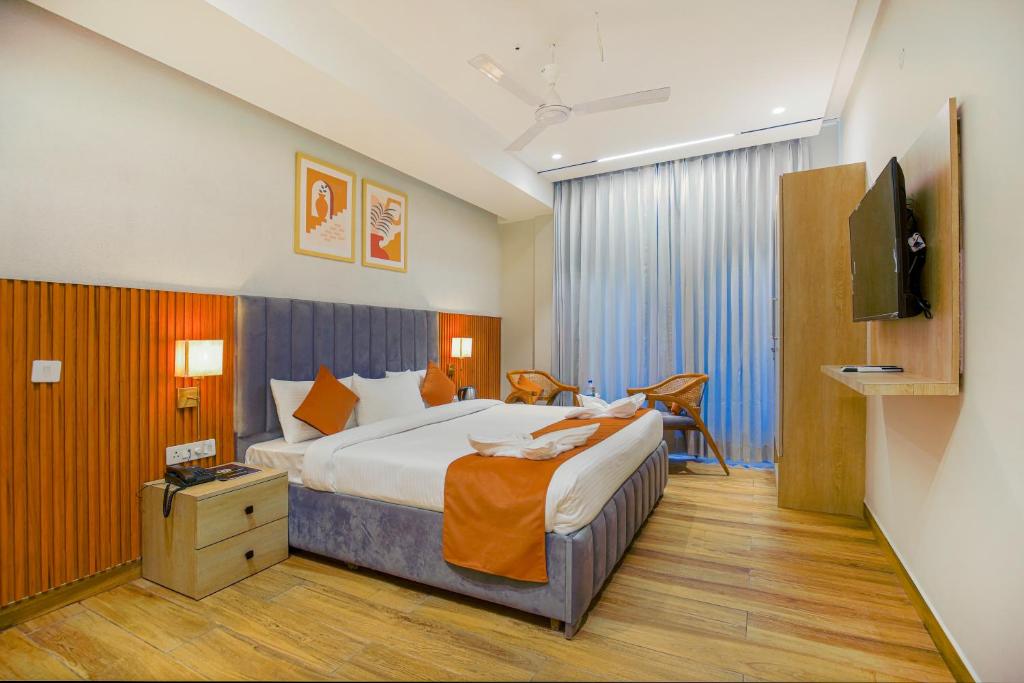 a hotel room with a large bed and a television at Hotel West Inn Premium in Kharar