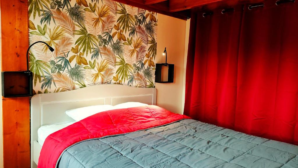 um quarto com uma cama com uma cortina vermelha em Gite 3 étoiles dans une grange rénovée - Cantal Emotions Valette - Auvergne em Valette