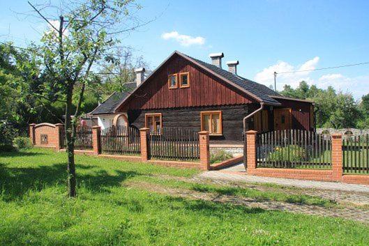 una casa de madera con una valla delante en chalupa u Pinkasů, en Střítež