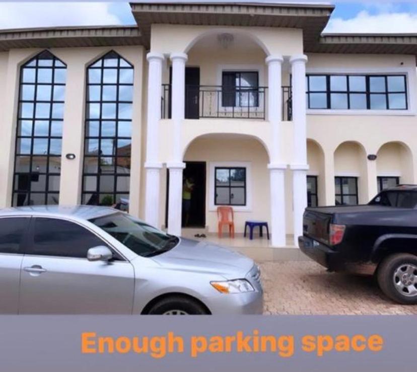 two cars parked in front of a house at Dovan Lodge Enugu in Enugu