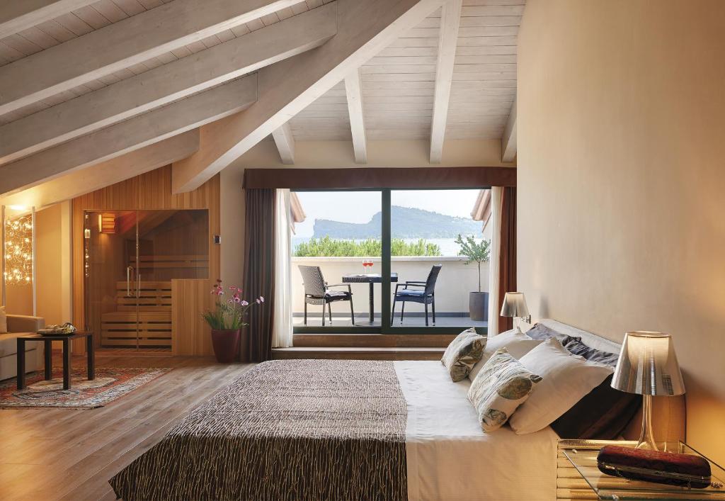 ein Schlafzimmer mit einem großen Bett und einem Tisch mit Stühlen in der Unterkunft Hotel Ristorante Sogno in San Felice del Benaco
