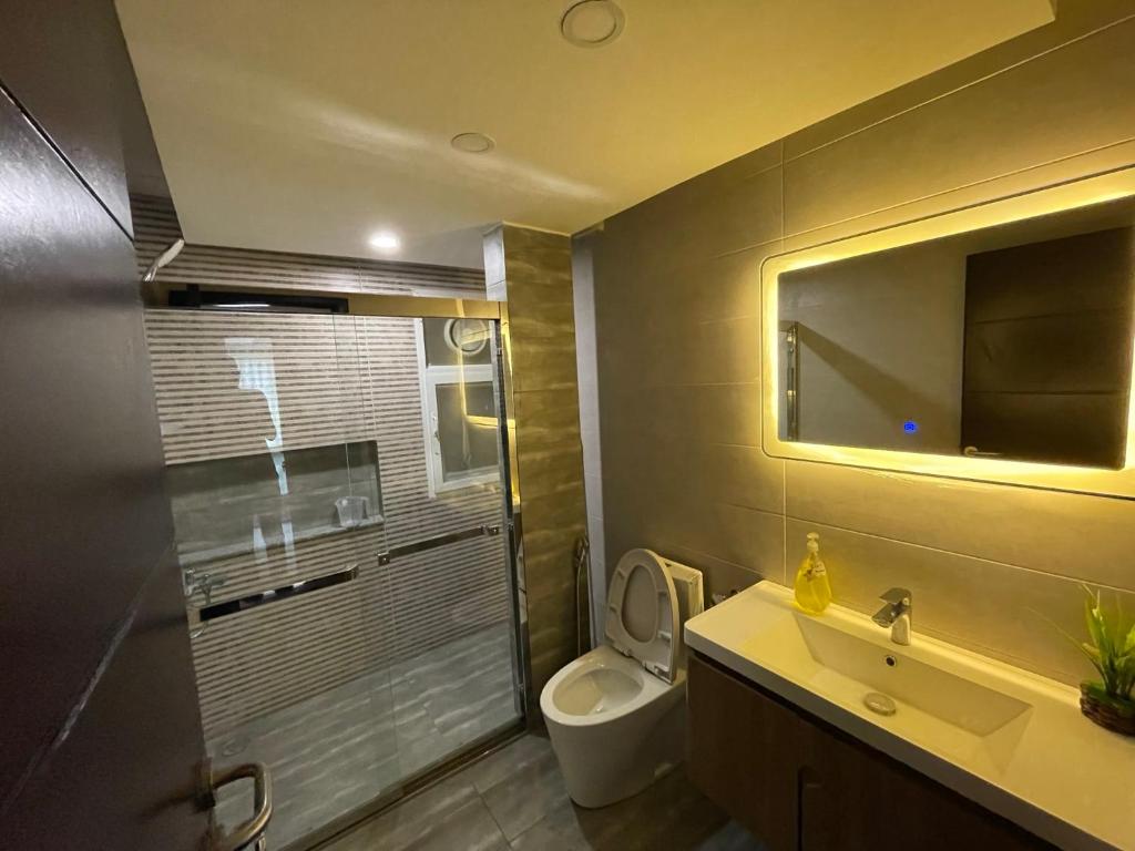 a bathroom with a toilet and a sink and a mirror at High-Rise Studio in Elysium Opp Centaurus in Islamabad