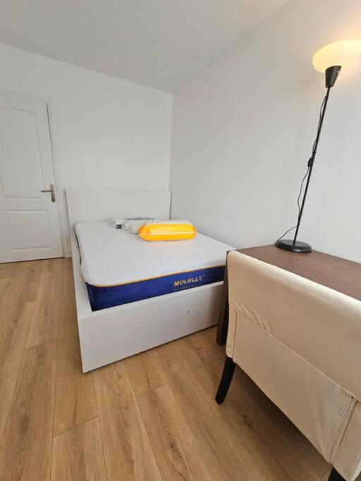a small bedroom with a bed and a lamp at Charmant appartement proche Paris in Épinay-sur-Seine