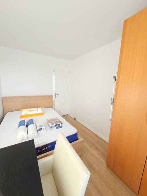 a small room with a bed and a chair at Charmant appartement proche Paris in Épinay-sur-Seine