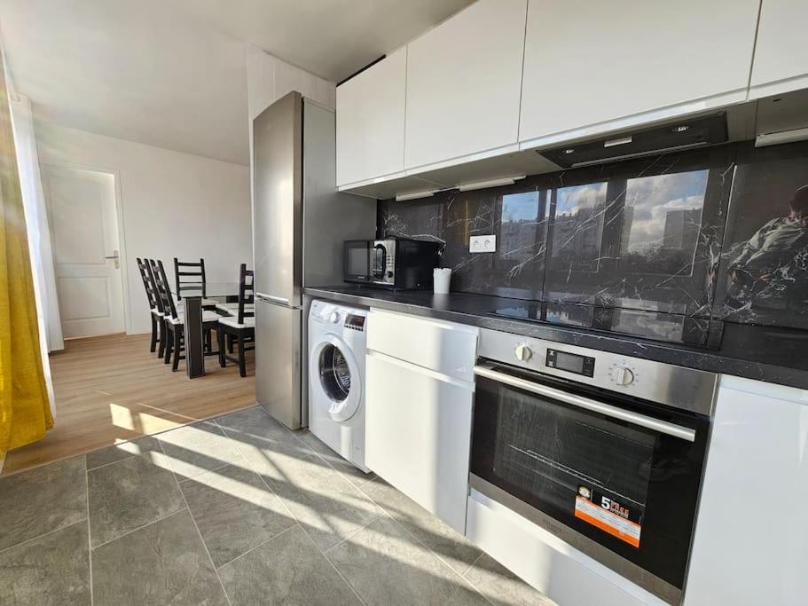 a kitchen with a washer and dryer in a room at Charmant appartement proche Paris in Épinay-sur-Seine