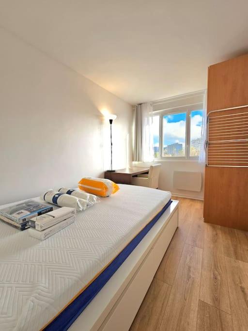 a large bed in a room with a window at Charmant appartement proche Paris in Épinay-sur-Seine