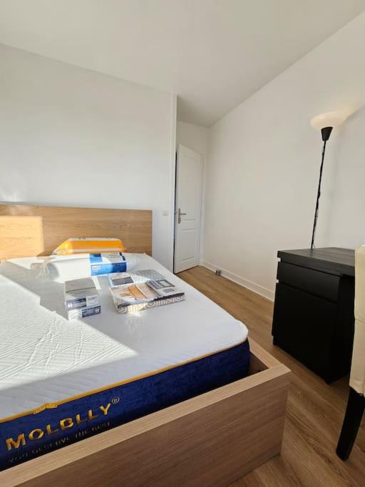 a bedroom with a bed with a blue mattress and a desk at Charmant appartement proche Paris in Épinay-sur-Seine