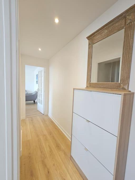 a room with a dresser with a mirror on top of it at Charmant appartement proche Paris in Épinay-sur-Seine