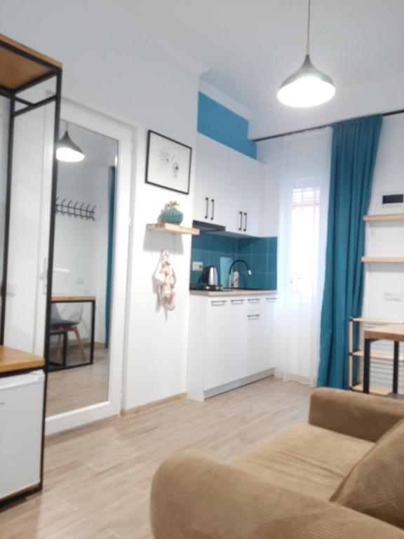 a living room with a couch and a kitchen at Marjani Terrace Rooms in Tbilisi City